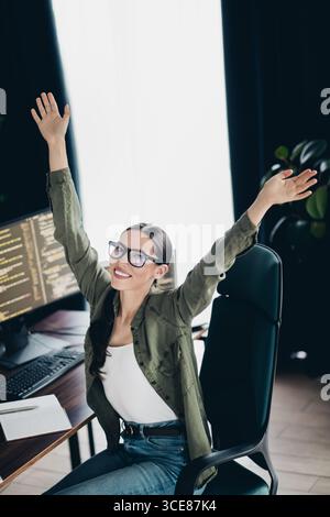 Professional computer programmer enjoying success while working remotely in a home office environment with a computer setup Stock Photo
