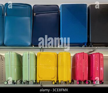 Travel suitcases and bags displayed on shelves, multicolored luggage Stock Photo