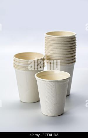 A stacked eco friendly disposable coffee cups, biodegradable paper cup, sustainable material, minimal design, neutral color, reusable alternative Stock Photo