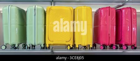 Multicolored  Travel suitcases and bags displayed on shelves Stock Photo