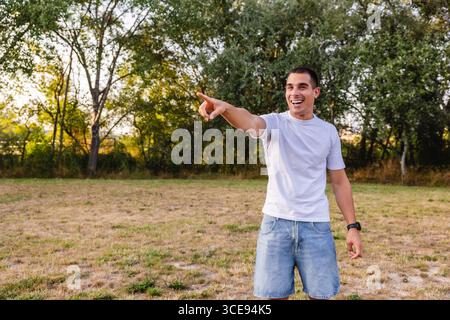 Young man pointing and laughing in a park Stock Photo