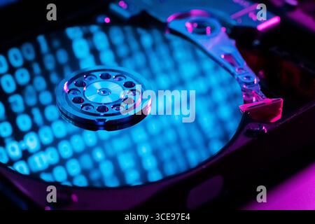 A close-up of a hard disk with an abstract reflection of the binary code Stock Photo