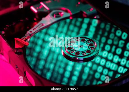The computer code is displayed in green numbers on the open hard disk Stock Photo