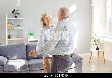 Happy Senior Couple Dancing Together At Home Stock Photo