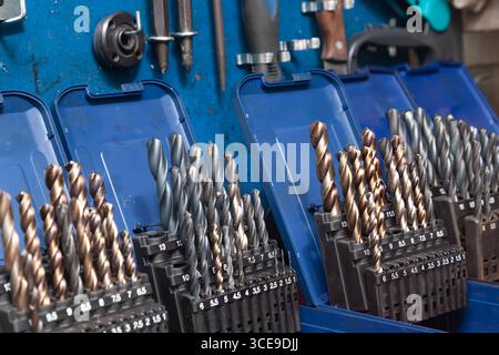 Sets of drills on a table in a workshop. Stock Photo