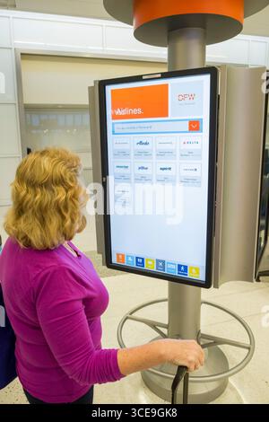 Woman using large interactive electronic display to find information on dining and services available inside Terminal E at the Dallas/Fort Worth Inter Stock Photo