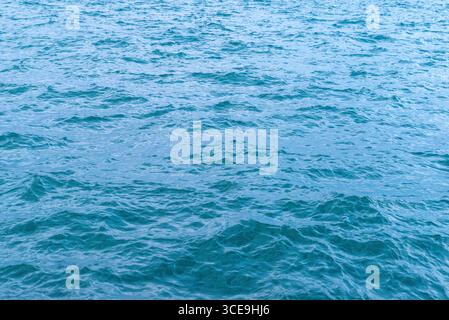 Tranquil blue sea with soft ripples and sunlight reflections, ideal for nature, summer, or peaceful vacation themes Stock Photo