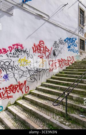 Graffiti on white wall along Escadinhas do Marquês de Ponte de Lima, Lisbon, Portugal Stock Photo