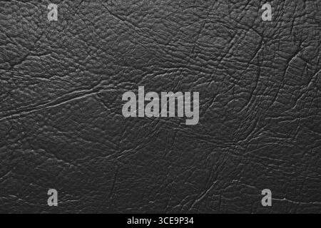 Close up, macro texture of black glossy natural genuine leather, leatherette structure, artifical skin surface with embossed pattern. Background, wall Stock Photo