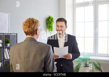 Young man and senior woman businesspeople meeting in the office and working together Stock Photo