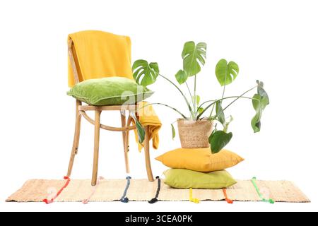 Chair with pillows, palm plant and carpet on white background Stock Photo