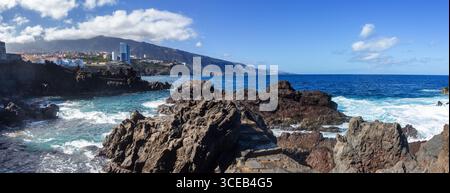 Scenic Rocky Shore, Punta Brava Atlantic Ocean Panorama.  Puerto de la Cruz, Tenerife Canary Islands Spain.  Cloud Covered Teide Volcano Skyline Stock Photo
