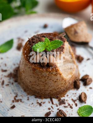 Homemade chocolate and coffee flan decorated with fresh mint. Traditional egg recipe. Stock Photo