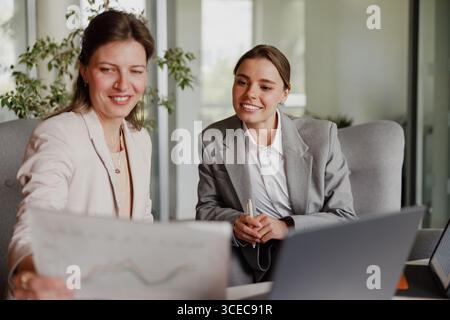 Professional Women Engaging in Collaborative Efforts within a Modern Office Environment Stock Photo