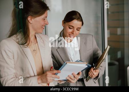 Professional Businesswomen Engaging in Collaborative Discussions within a Modern Office Space Stock Photo