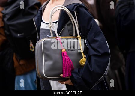 Paris, France - March 11, 2025: Gray Miu Miu leather top handle bag with colorful tassels and charm details. Street style outfit details Stock Photo