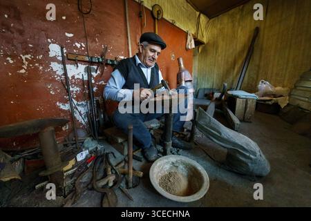 Copper craftsman works in his workshop in Lahic, Azerbaijan Stock Photo