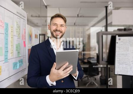 Happy successful young executive man using Internet technology Stock Photo