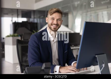 Happy young company executive man typing on keyboard Stock Photo