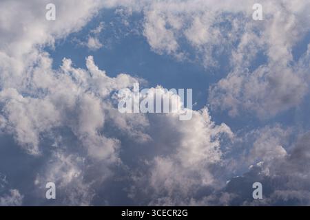 Fluffy white clouds float across a serene blue sky, captured in the picturesque region of Kakheti, Georgia. The image evokes a sense of tranquility an Stock Photo