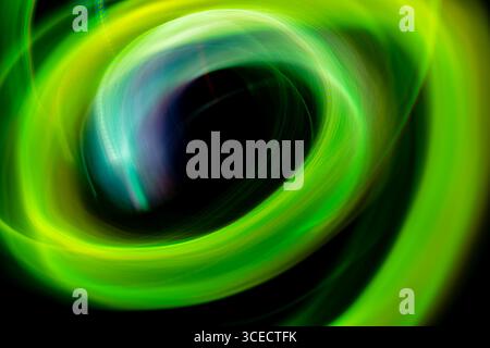 A dynamic swirl of vibrant green neon lights creating an abstract, ethereal pattern, captured using long exposure photography for a mesmerizing visual Stock Photo