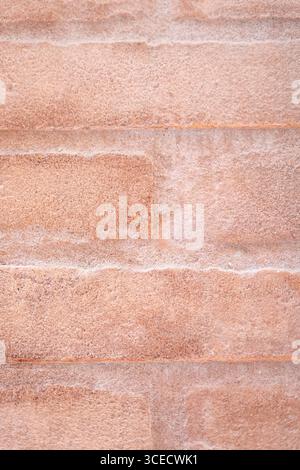 Close-up image of a rough beige stone surface, displaying a natural, textured pattern. The intricate details showcase the tactile quality of the stone Stock Photo