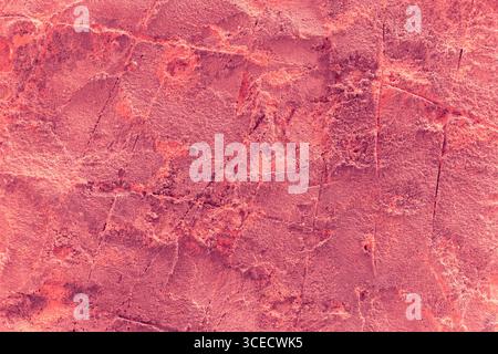 A close-up image of a textured red stone surface with intricate patterns and subtle variations in color, showcasing a rough and natural appearance ide Stock Photo