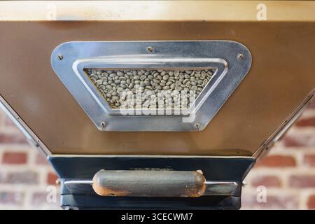 Industrial coffee roasting machine with a view of green coffee beans inside the hopper. Perfect for small batch and artisanal coffee production in a m Stock Photo