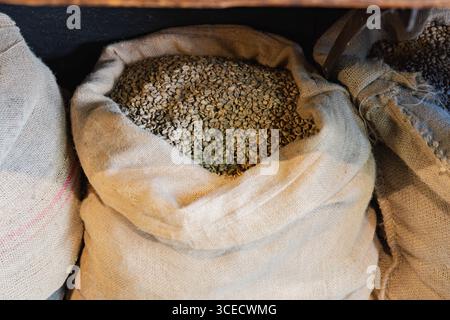 Burlap sacks filled with raw coffee beans are ready for the roasting process in this artisanal coffee shop. The beans await transformation into specia Stock Photo
