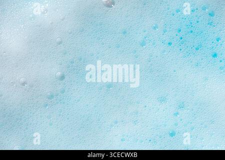 A close-up view of a blue foam texture, showcasing an intricate pattern of delicate bubbles. The soothing shade of blue highlights the foam's soft and Stock Photo