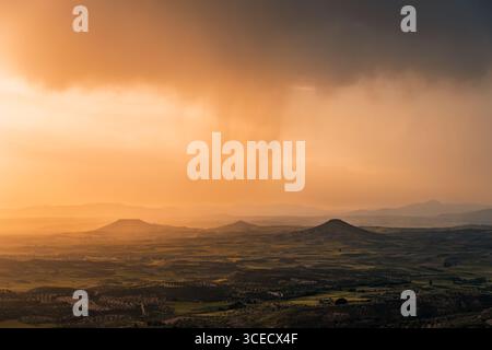 A breathtaking aerial view of a stormy Alcarria landscape during sunset. Dramatic clouds and golden light create a mesmerizing scene in Guadalajara, S Stock Photo