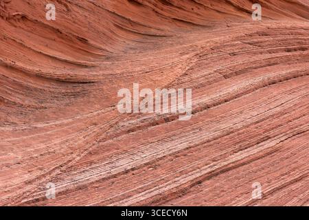 Red sandstone formations create a visually striking abstract texture with layered patterns. The natural curves and lines evoke the beauty of geologica Stock Photo