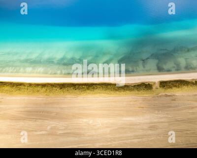 A breathtaking aerial view of Pangong Tso lake in Ladakh with vibrant blue waters, sandy shores, and contrasting green vegetation, showcasing the pris Stock Photo
