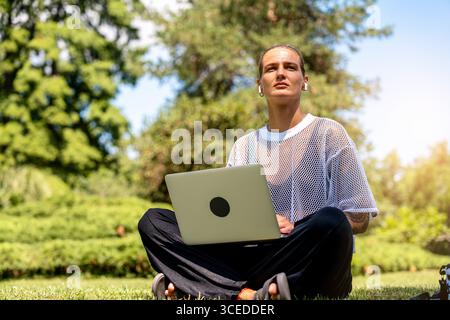 Concentrated female professional working on computer in park Stock Photo