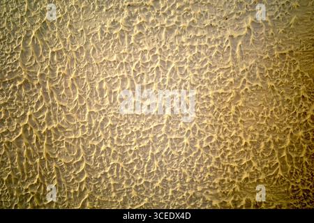 Gold concrete cement wall for interiors, art wallpaper or artistic texture background. Stock Photo