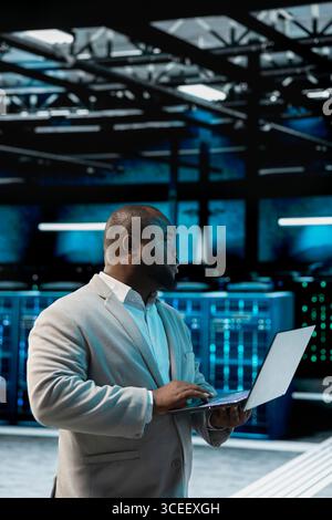 Data center admin running system diagnostic tests and error checking utilities, automating anomaly detection. IT expert monitoring server performance, looking for network issues affecting rigs Stock Photo