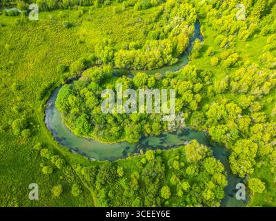 In the Weisspriach Valley, clear water flows through green trees and ...