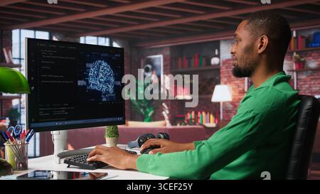 African american engineer coding a neural network AI brain model for machine learning and deep learning, solving IT support tasks on pc. Debugging software and checking for errors. Camera B. Stock Photo