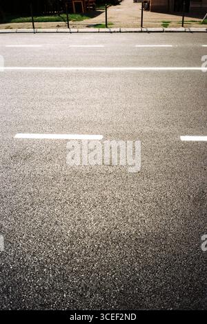 Freshly painted vertical signage on a newly paved local concrete road, photographed analog-style with Kodak Gold and an Olympus Mju, in a high-contras Stock Photo