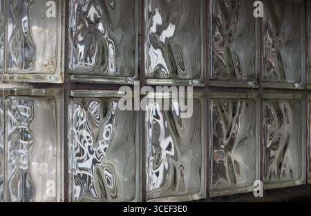 reflections in glass blocks making abstract designs and patterns  from light shining through them some resembling faces horizontal conceptual graphic Stock Photo