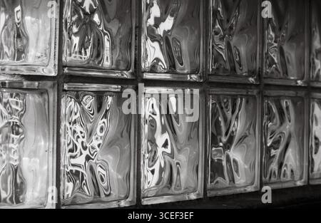 reflections in glass blocks making abstract designs and patterns  from light shining through them some resembling faces horizontal conceptual graphic Stock Photo