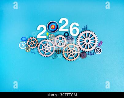 Number 2026 with wooden gears and business icons on blue background, symbolizing New Year growth planning, success strategy, teamwork, system developm Stock Photo