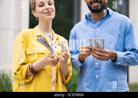 Couple Holding Stacks of Money Stock Photo