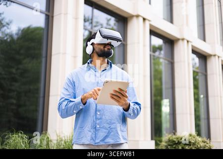 Man Using VR Headset and Tablet Stock Photo