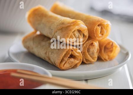Fried spring rolls on plate on a white table. Stock Photo
