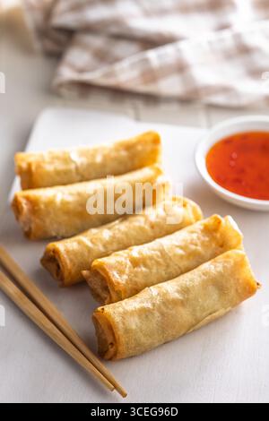 Fried spring rolls with sweet and saur sauce on a white table. Stock Photo