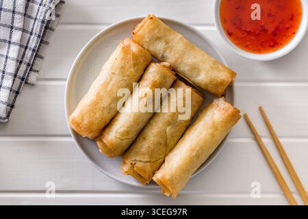 Fried spring rolls on plate on a white table. Top view. Stock Photo