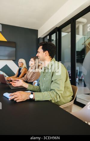 A team of young men and women gathers in a boardroom, engaging in productive discussions, fostering a collaborative environment and exchanging innovat Stock Photo
