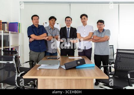Group of business people joining, holding hands showing teamwork in the office. Stock Photo