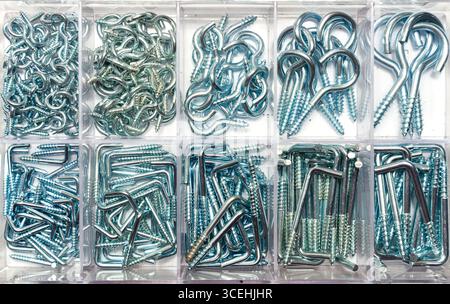 A box of new steel wall hooks of various sizes, stored in plastic cells. Stock Photo
